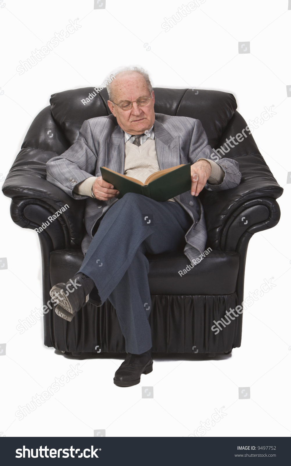 Senior Man Sitting In An Armchair And Reading A Book Stock Photo