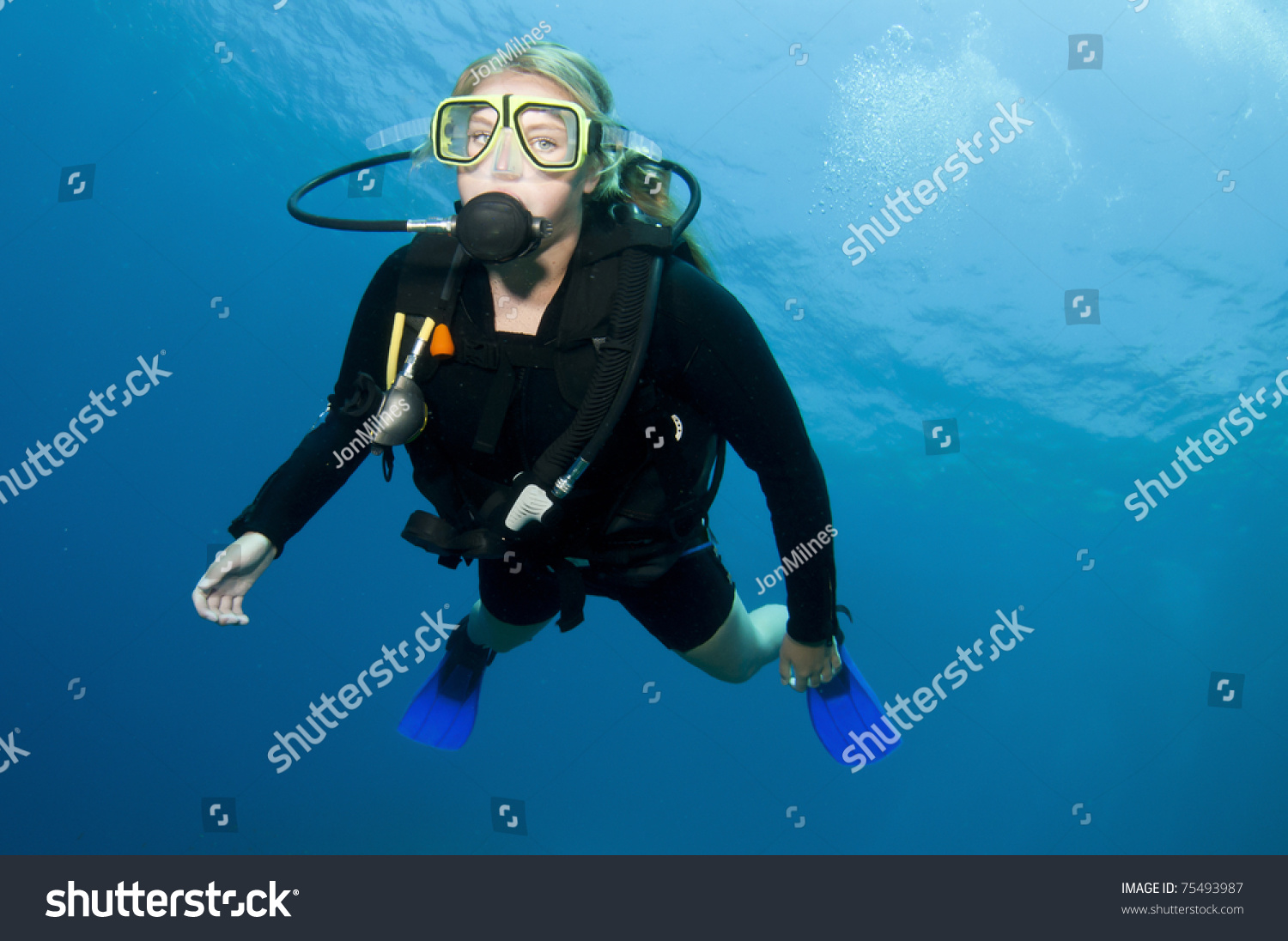 Sexy Attractive Blonde Girl Scuba Diving In Clear Blue Water On A Coral Reef In The Ocean