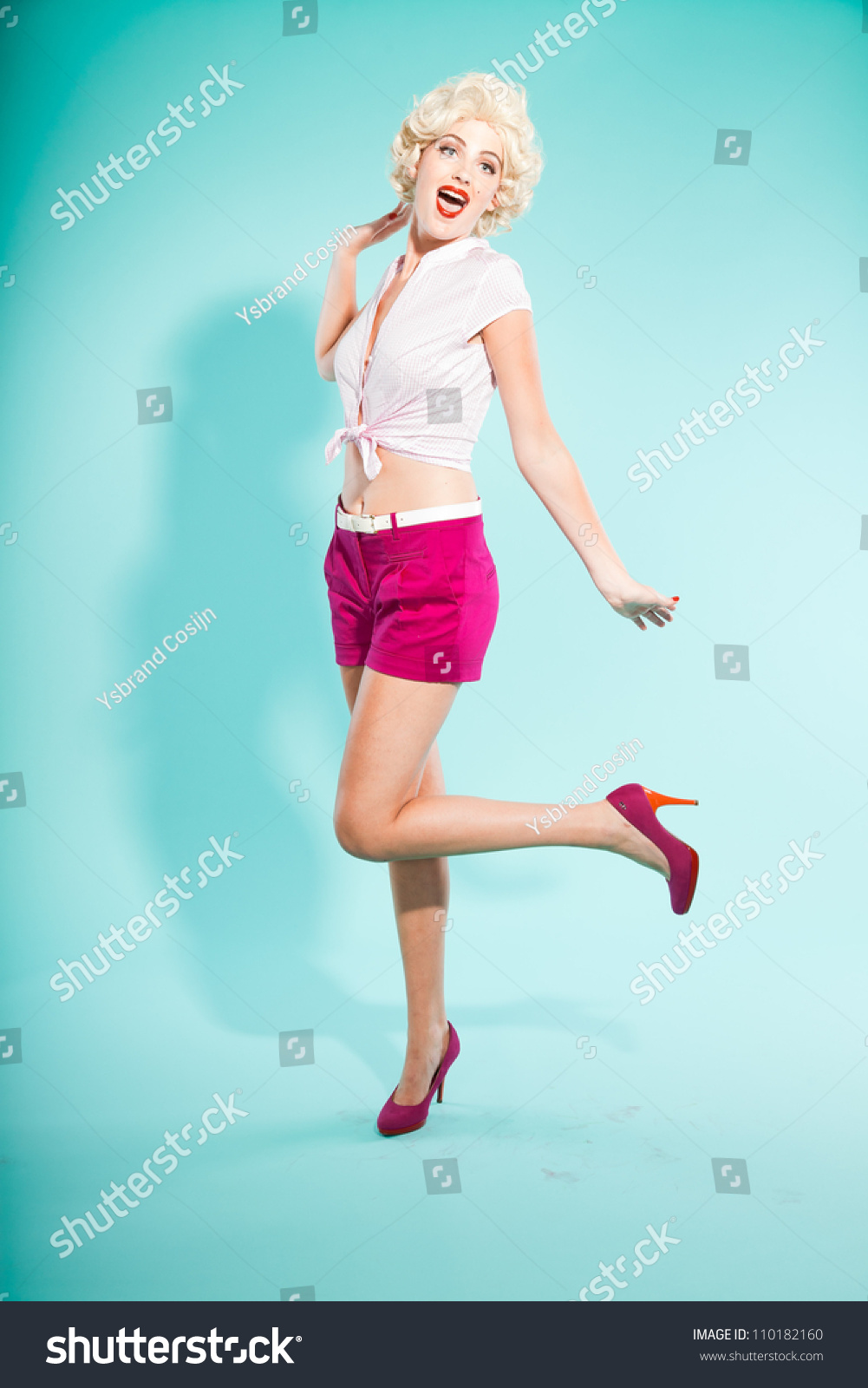 Sexy Blonde Pin Up Girl Wearing Pink Shirt And Hot Pants Retro Style