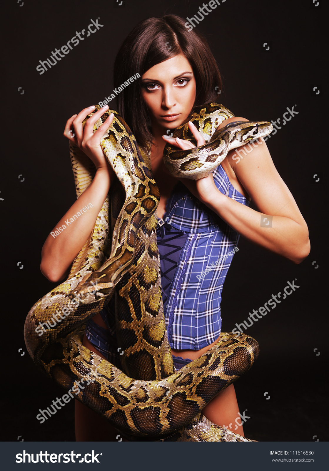 Sexy Brunette Holding Python Over Black Stock Photo