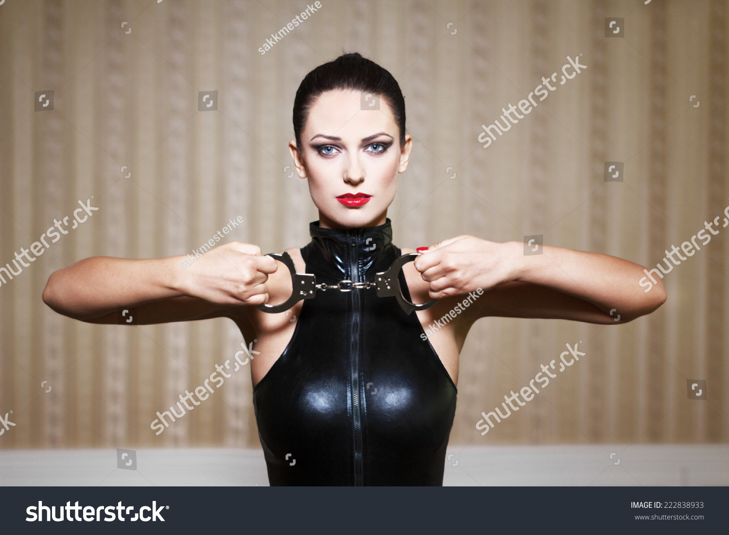 Sexy Brunette Woman In Latex Catsuit Holding Handcuffs Bdsm Stock