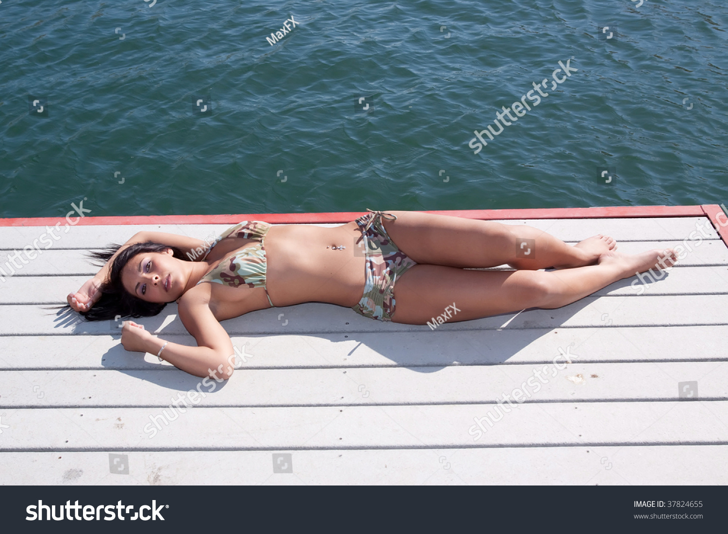 Sexy Woman Suntanning In A Bikini By The Lake Stock Photo