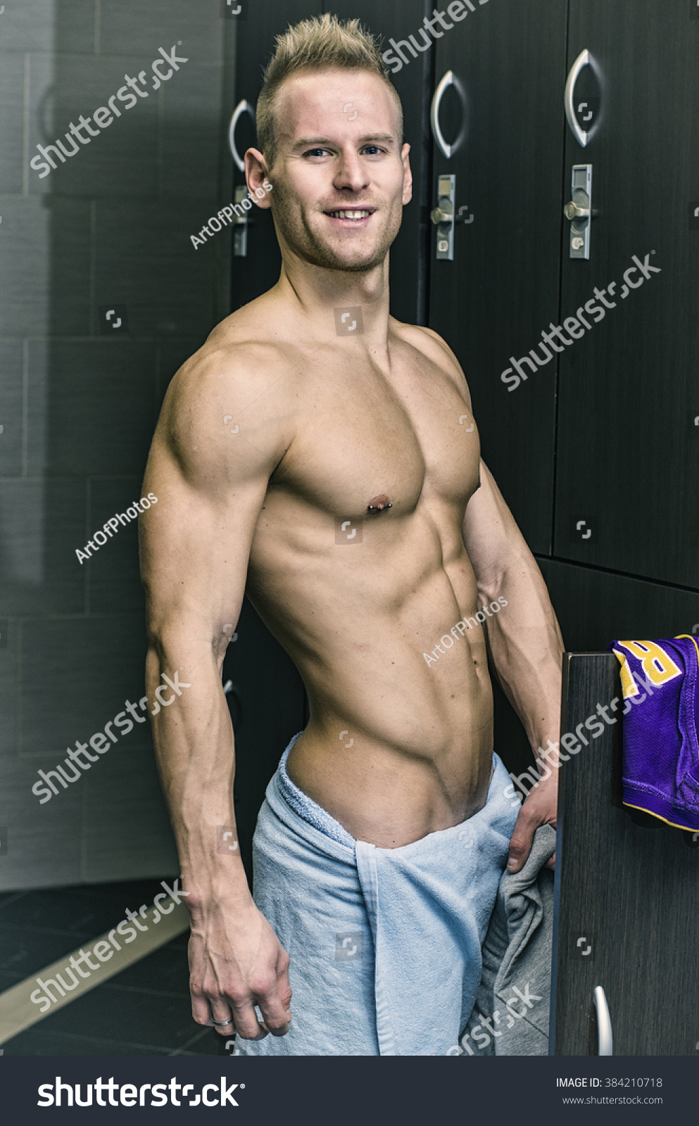 Shirtless muscular young male athlete in gym dressing room 