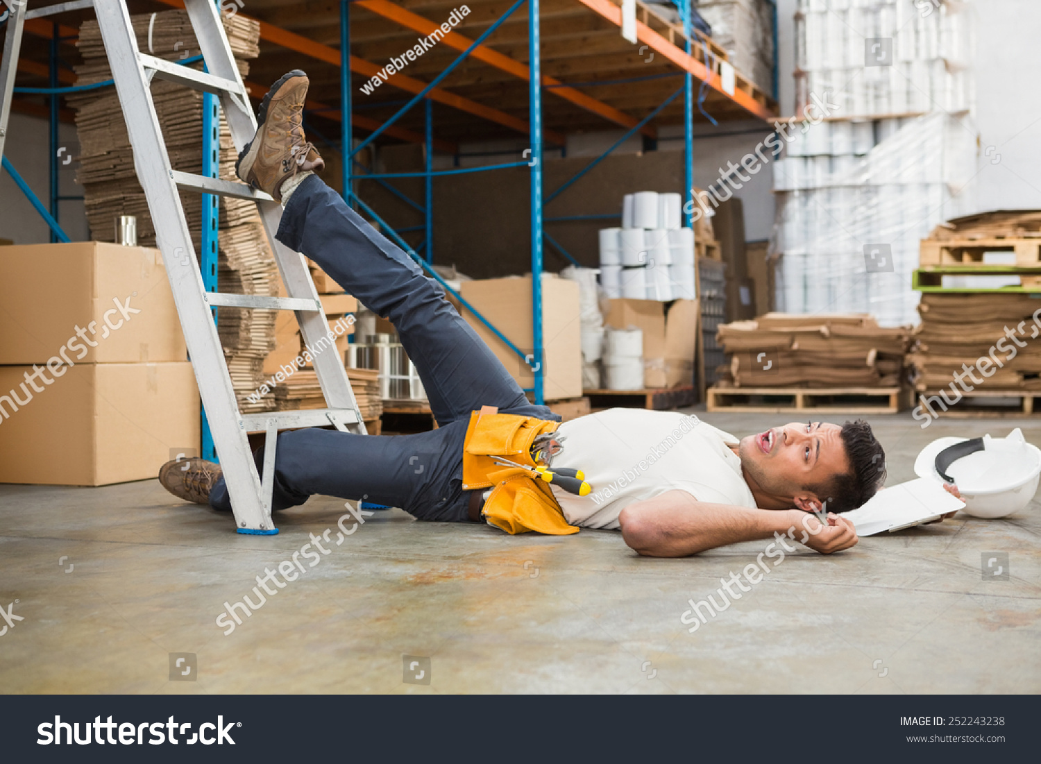 Side View Of Male Worker Lying On The Floor In Warehouse Stock Photo 