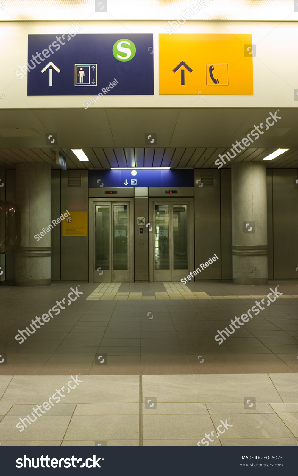 Signposts directing to a life and a telephone booth on the ground floor of a building Signposts directing to a life and a telephone booth on the ground floor of a building