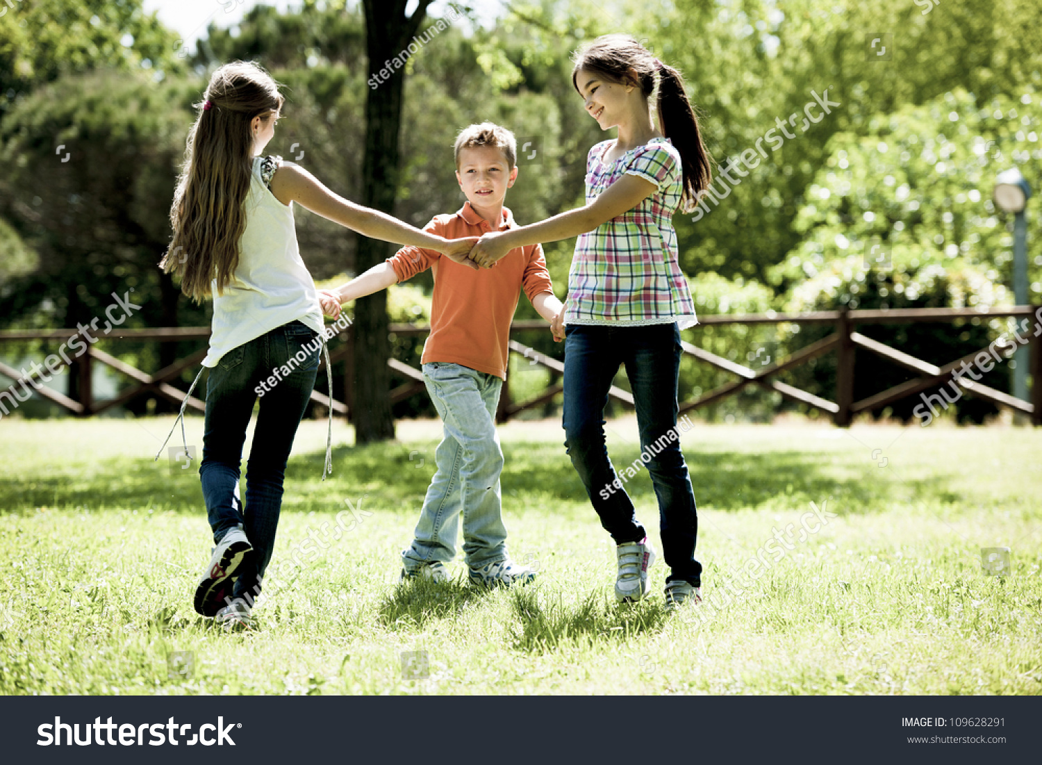 Small Group Of Children Playing Ring Around The Rosy Stock Photo