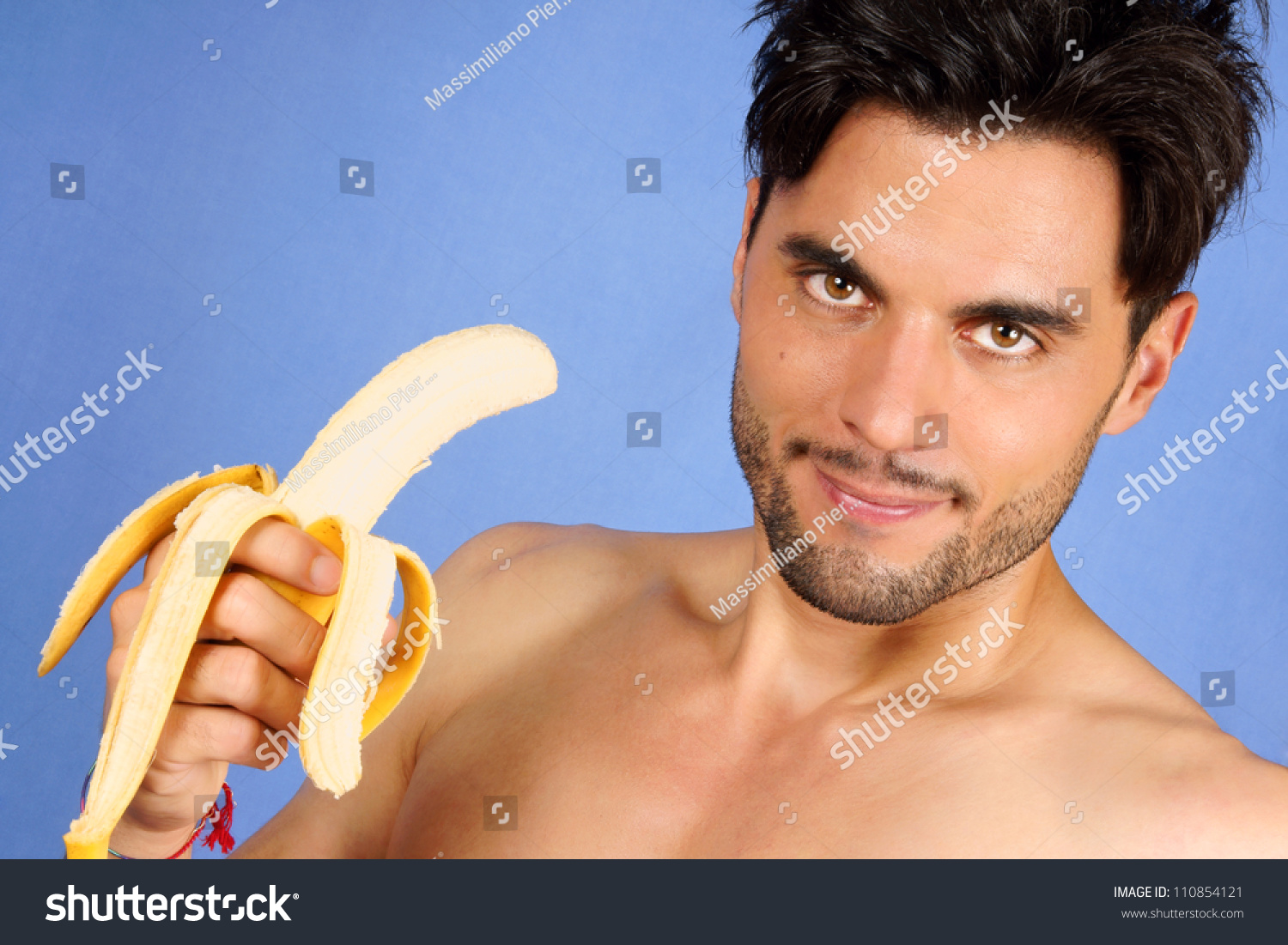 Smiling 30 Years Old Man With Banana Over A Blue Background With Copy