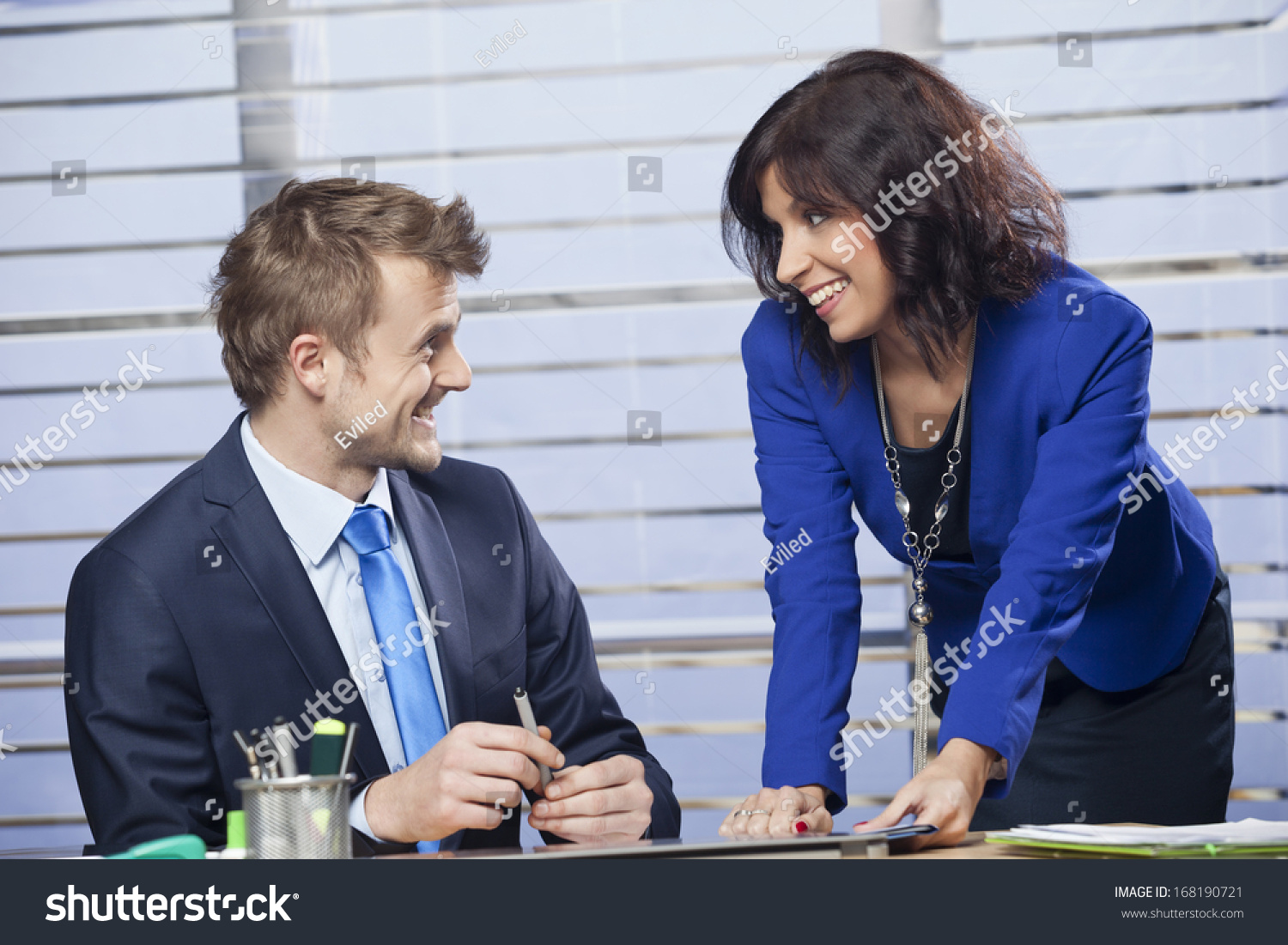 Smiling Young Business Woman Flirting With A Man In The Office