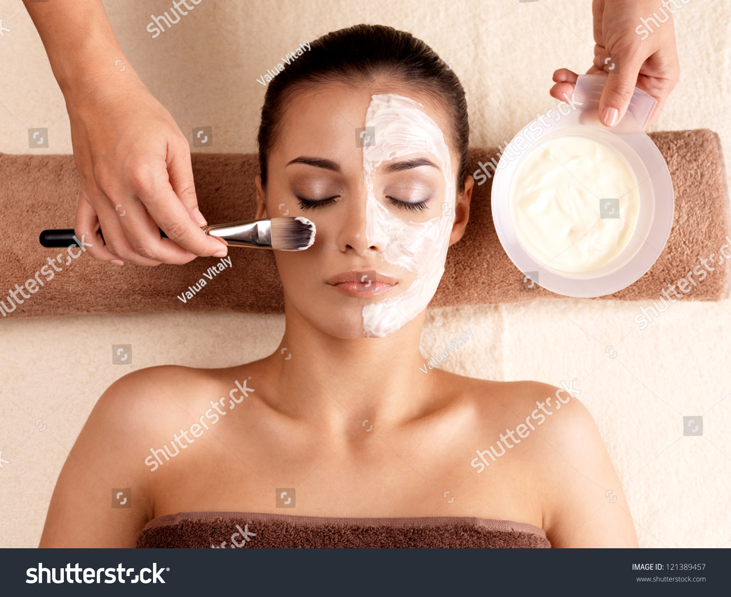 Spa Therapy For Young Woman Receiving Facial Mask At Beauty Salon