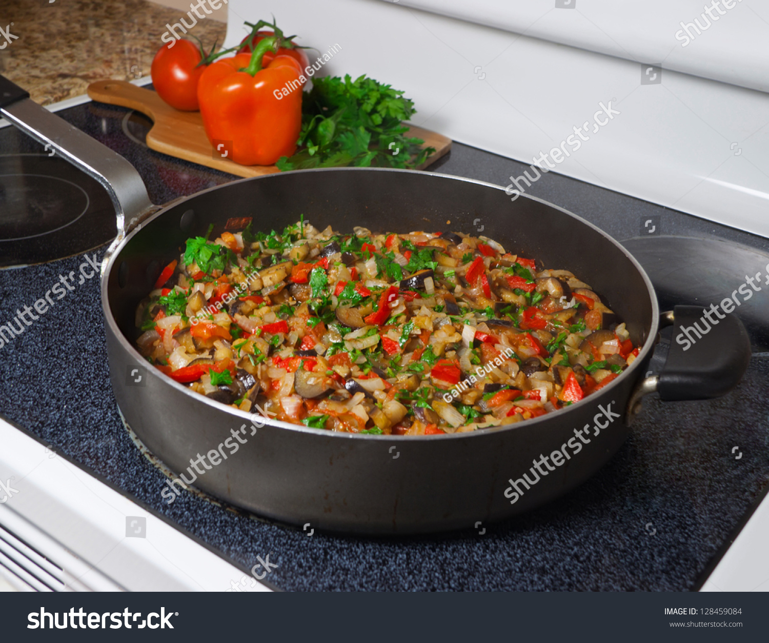 Stove Top With Vegetable Stew In Frying Pan And Cutting Board With