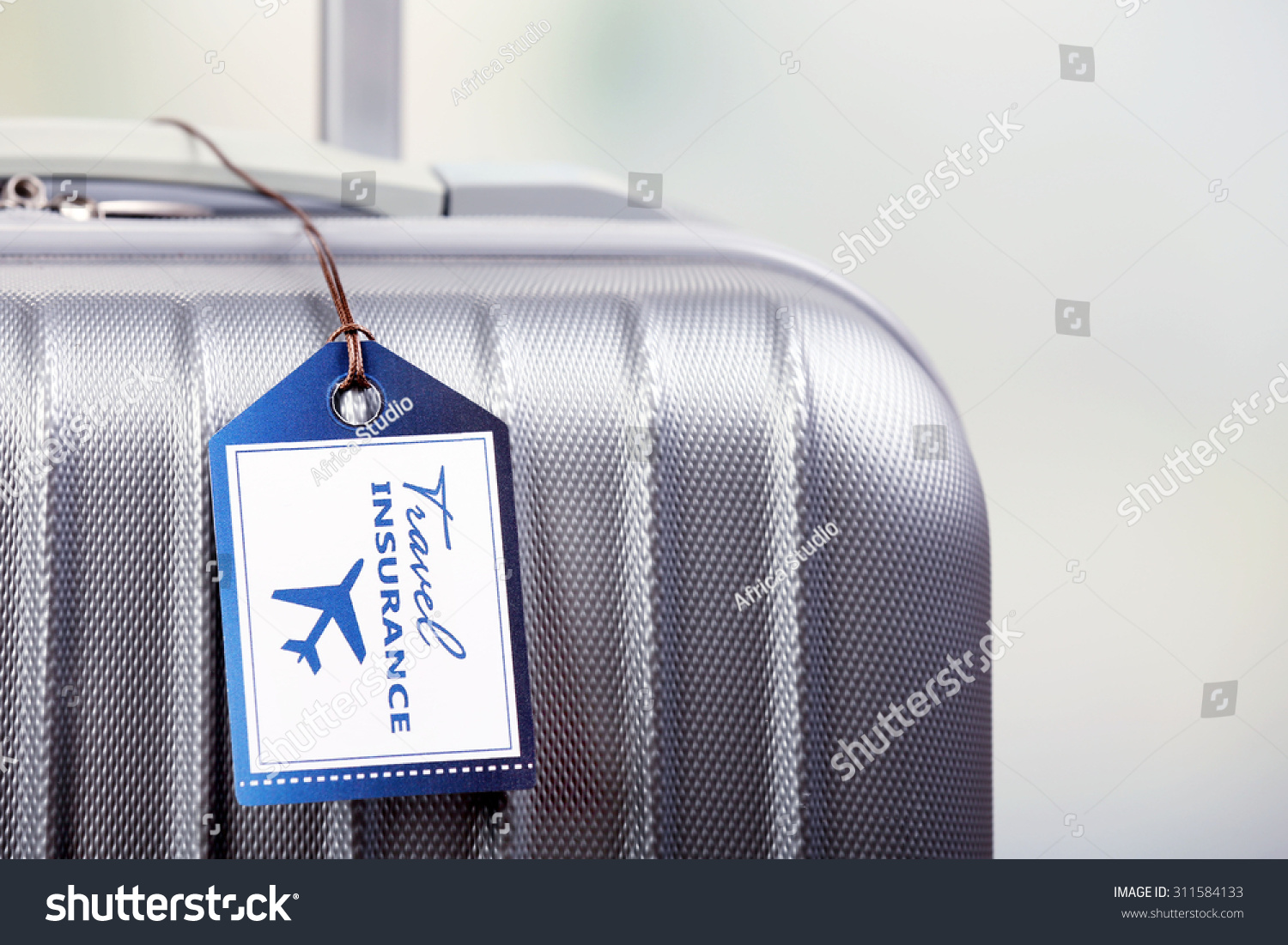 Suitcase with TRAVEL INSURANCE label on light blurred background Suitcase with TRAVEL INSURANCE label on light blurred background