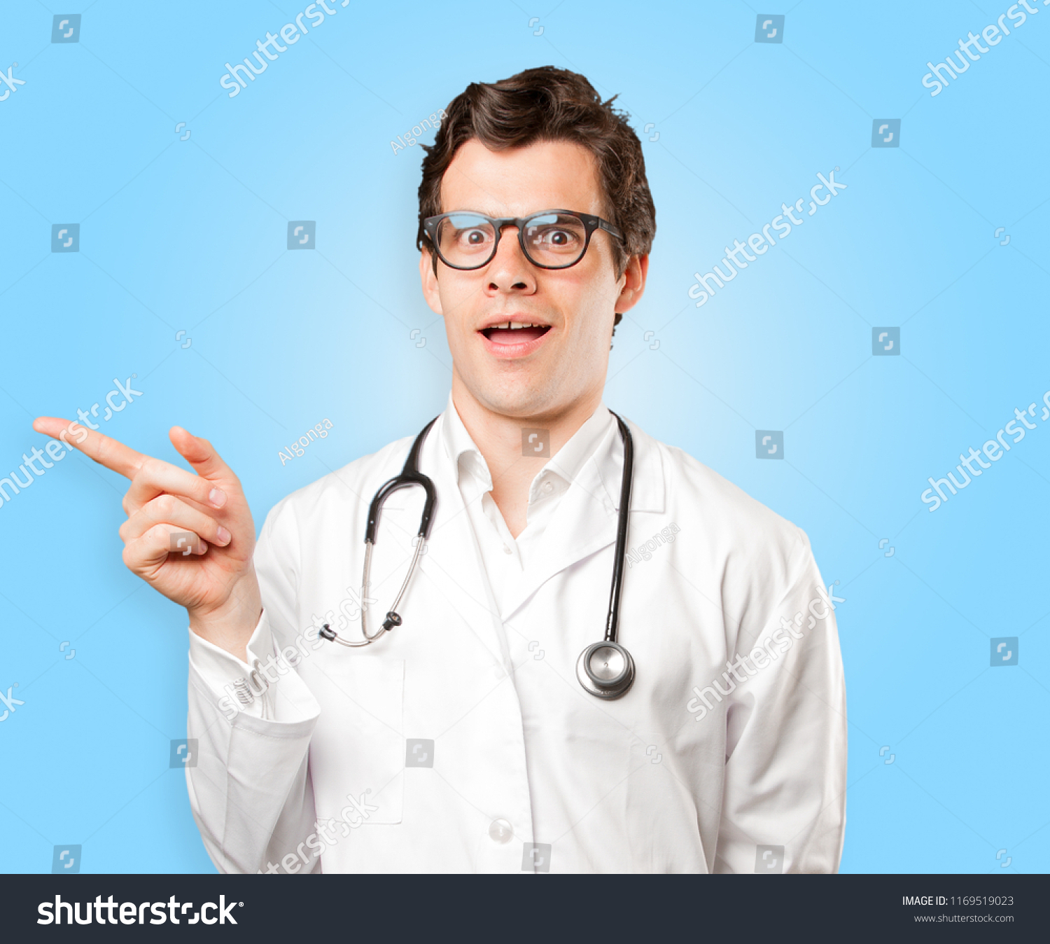 Surprised Doctor Pointing Against White Background Stock Photo