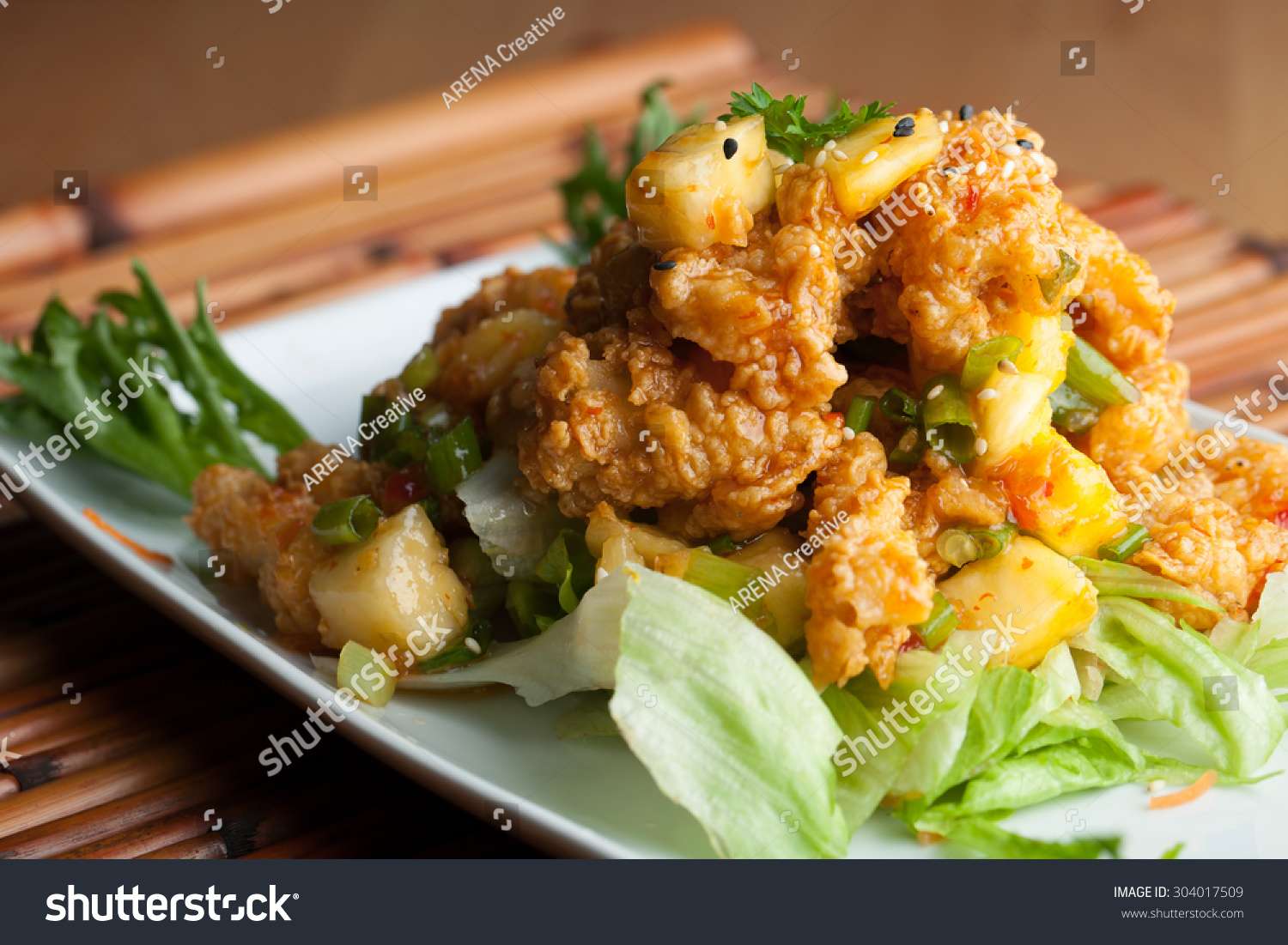 Thai Fried Calamari Appetizer Garnished With Fresh Pineapple Chunks Stock Photo