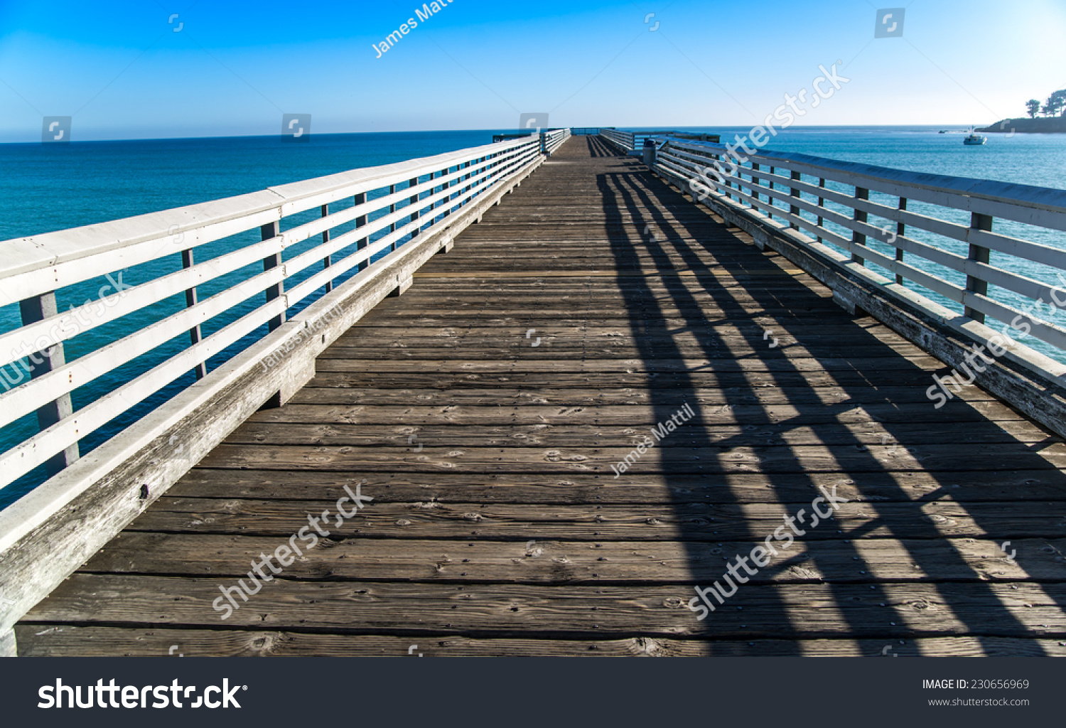 The historic wooden pier at San Simeon reaches into the blue Pacific Ocean The historic wooden pier at San Simeon reaches into the blue Pacific Ocean