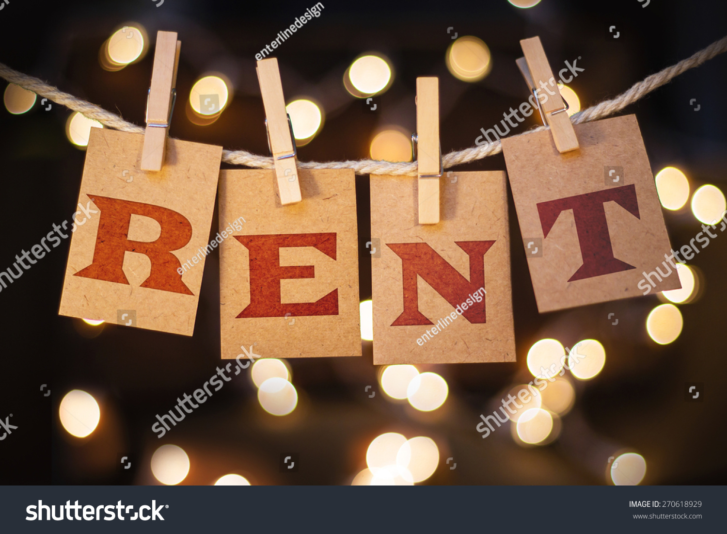 the-word-rent-printed-on-clothespin-clipped-cards-in-front-of-defocused