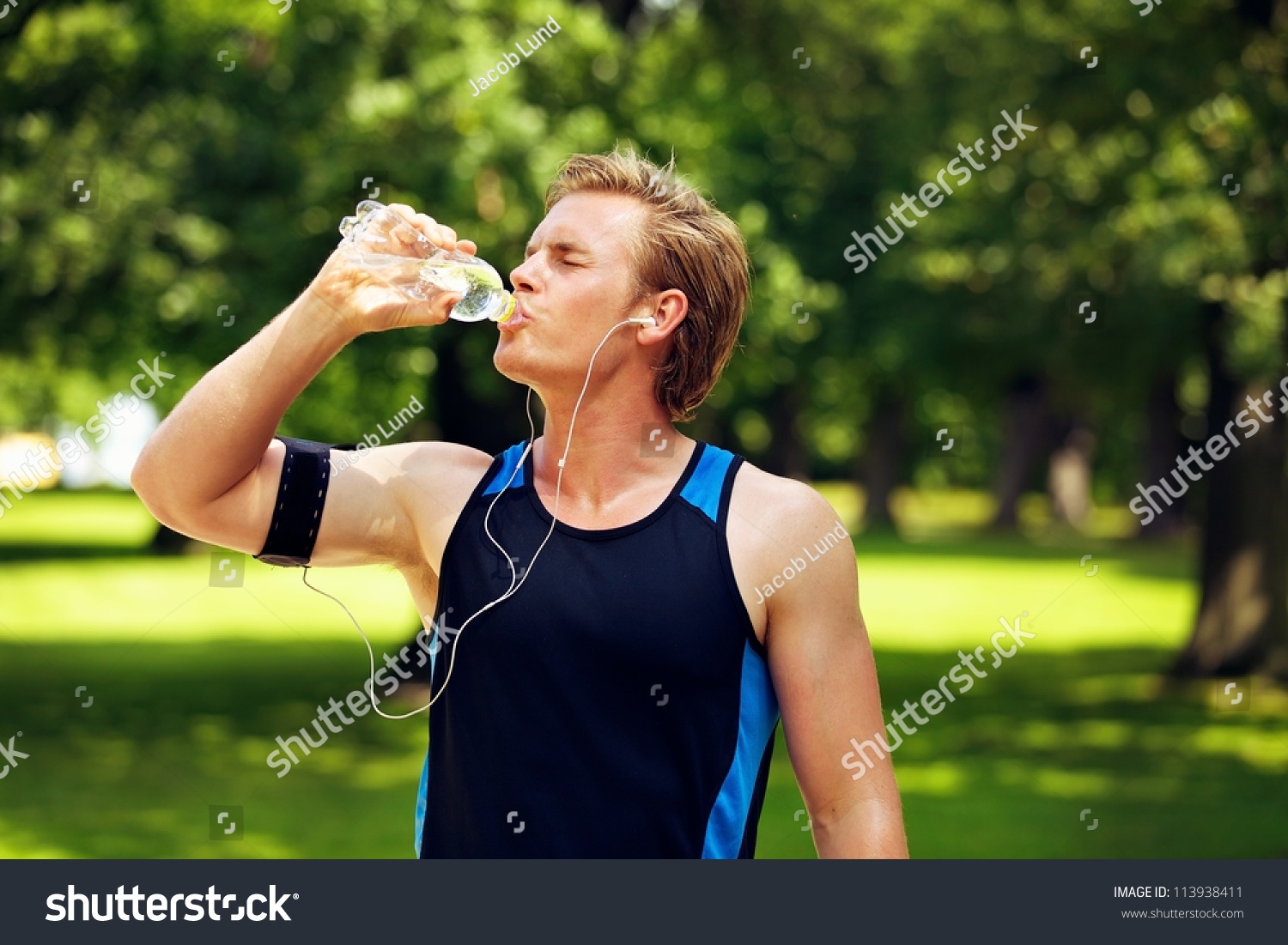 thirsty-athlete-drinking-water-after-workout-stock-photo-113938411