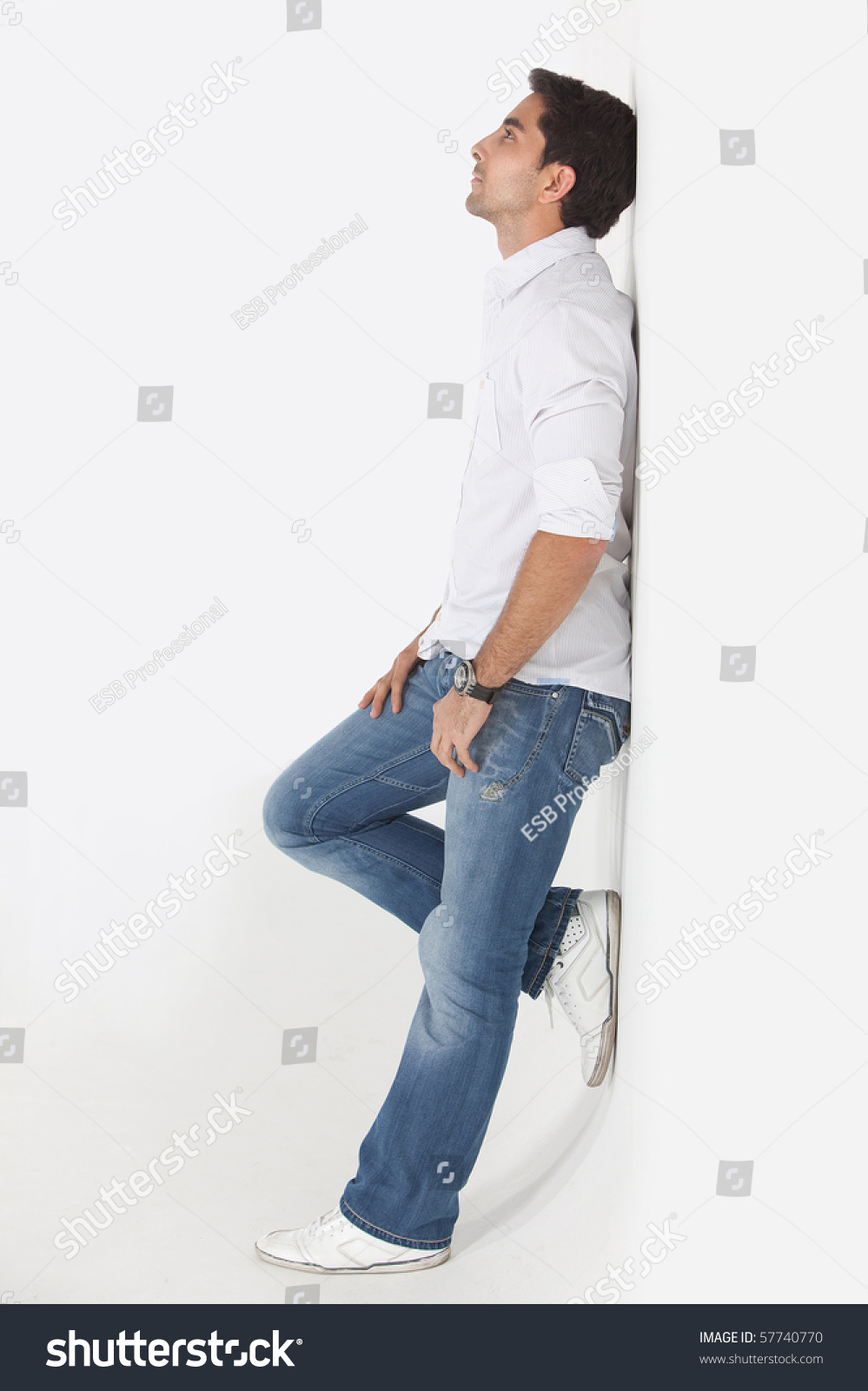 Thoughtful Man Leaning Against Wall Smiling Stock Photo