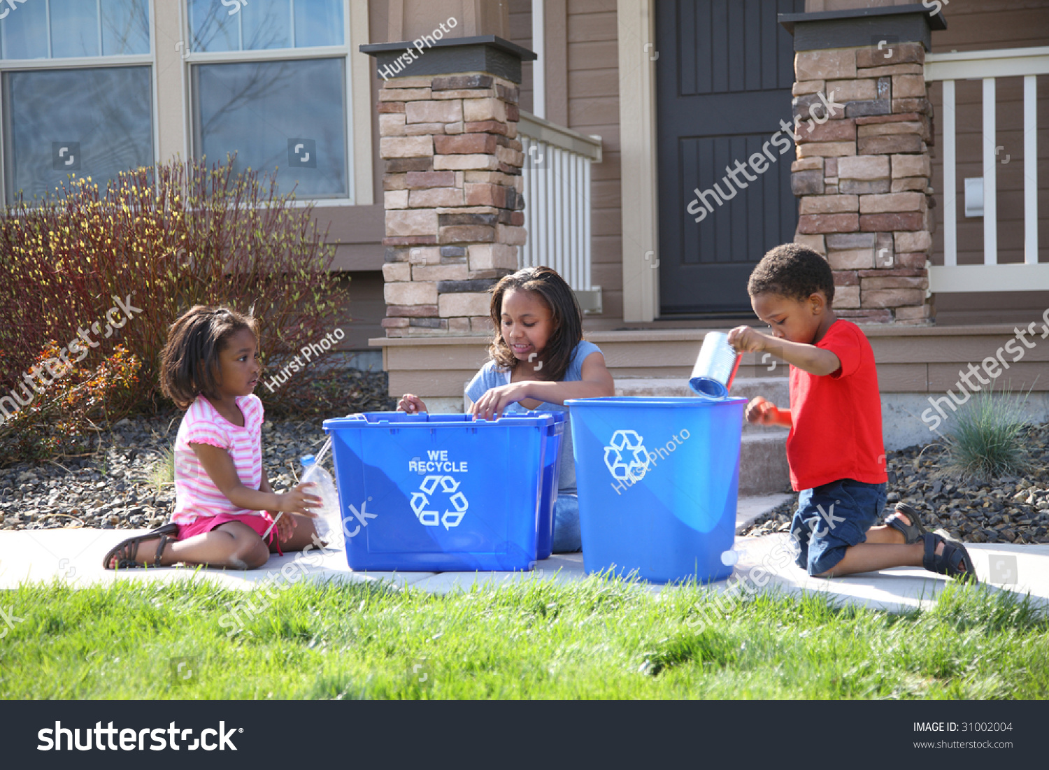 Three Children Putting Items Into Recycle Bin Stock Photo 31002004