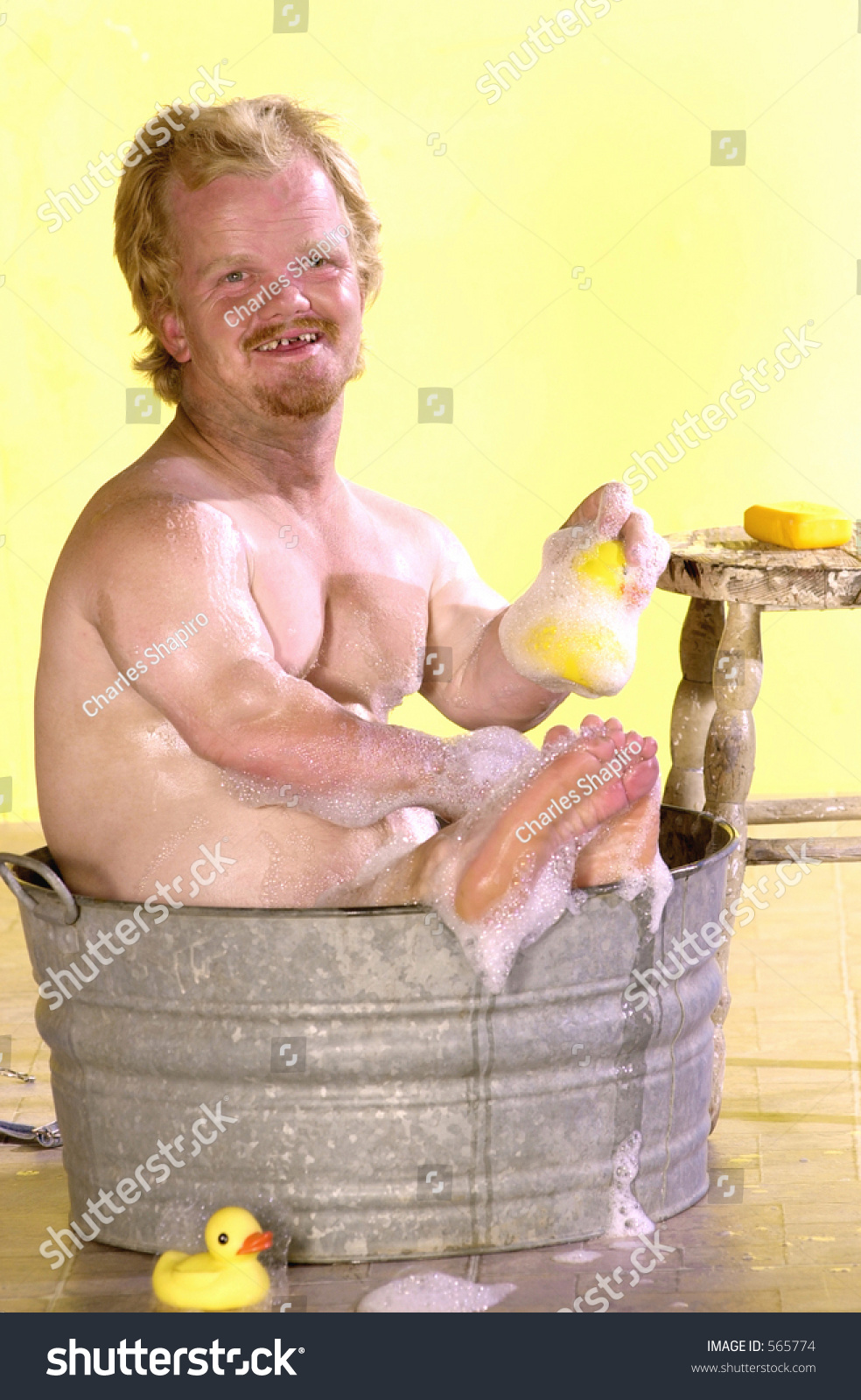 Tiny Man Takes A Bath In A Bucket Of Soapy Water With A Rubber Ducky