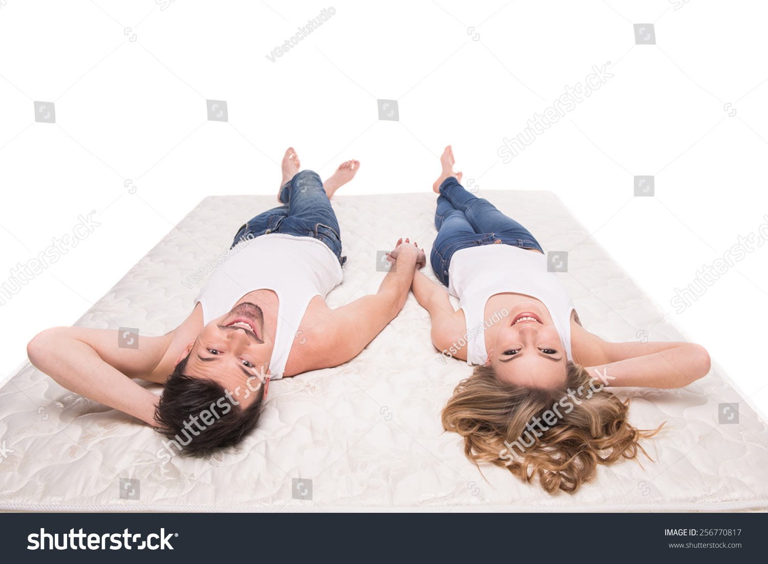 Top view of young beautiful couple are lying on the quality mattress Top view of young beautiful couple are lying on the quality mattress