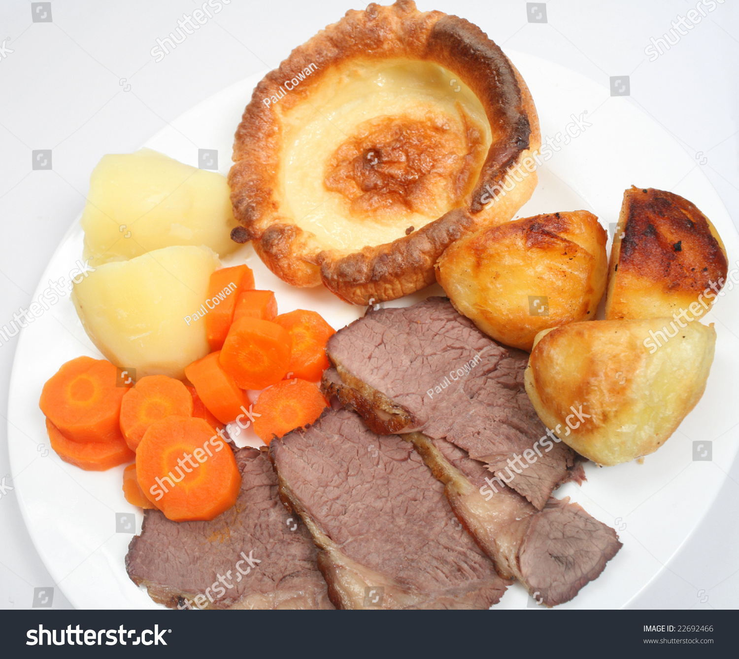 Traditional British Sunday Dinner Of Roast Beef And Yorkshire Pudding, With Boiled And Roasted
