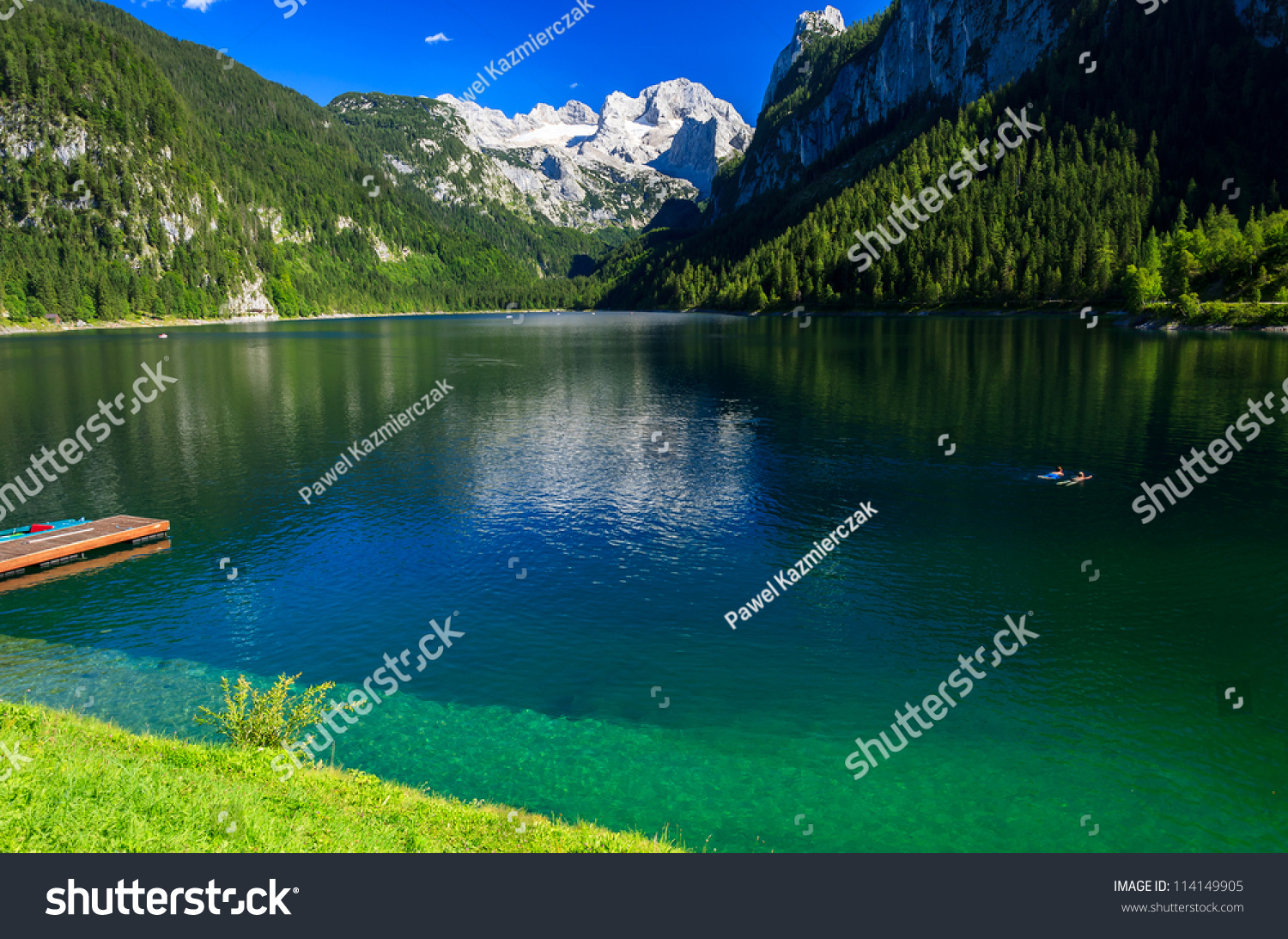 Two People Swimming In Alpine Lake With Crystal Clear Green Water And