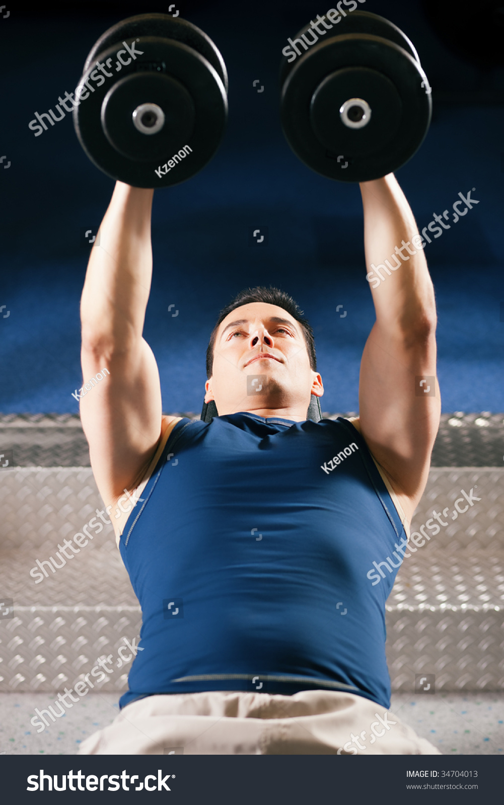 Very Strong And Handsome Man Lifting Weights Dumbbells In A Gym Stock
