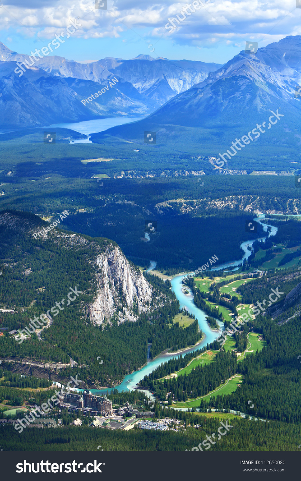 View Of A Bow River Valley And Golf Courses Against Rocky Mountains