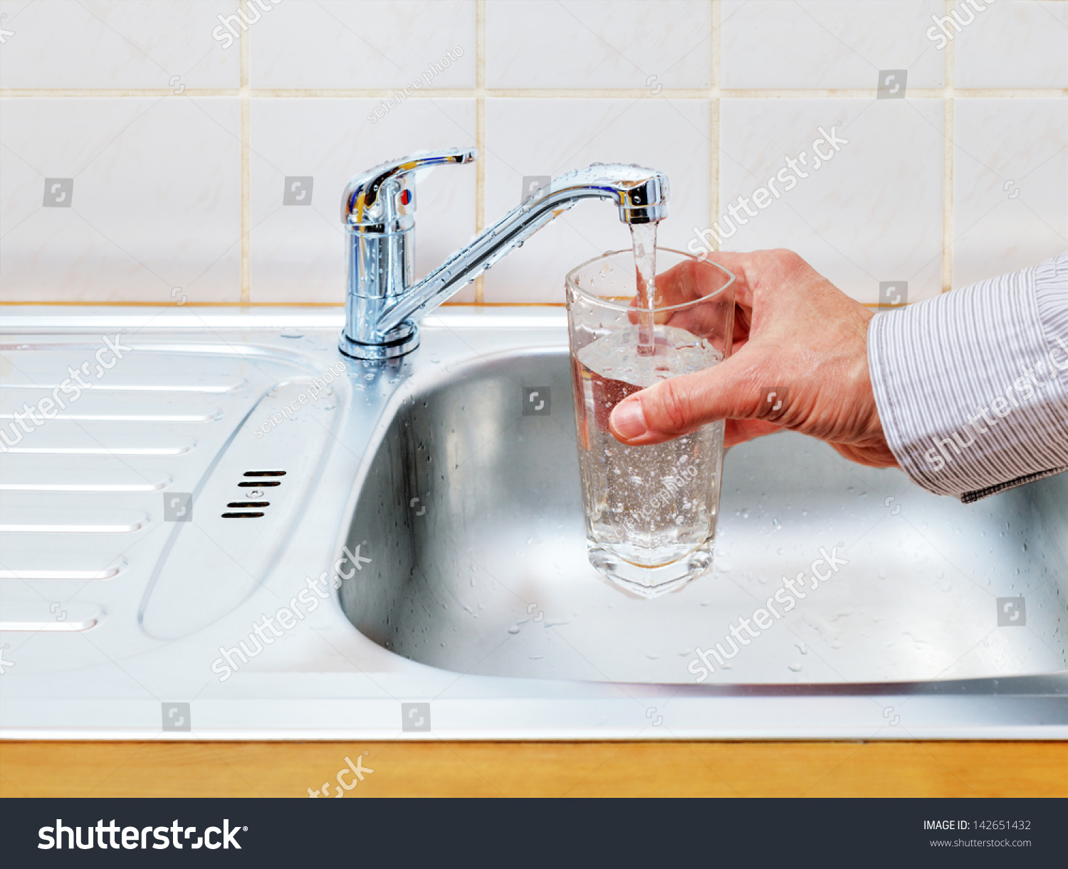 water-from-the-tap-is-poured-into-a-glass-stock-photo-142651432