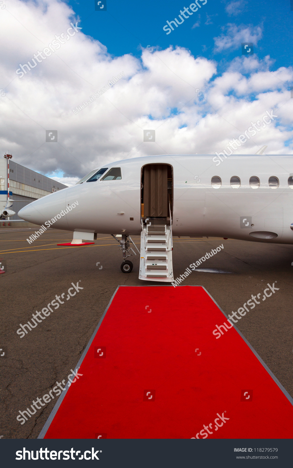 White Private Jet And Open Ladder, Red Carpet At Airport, Background Blue Sky Stock Photo