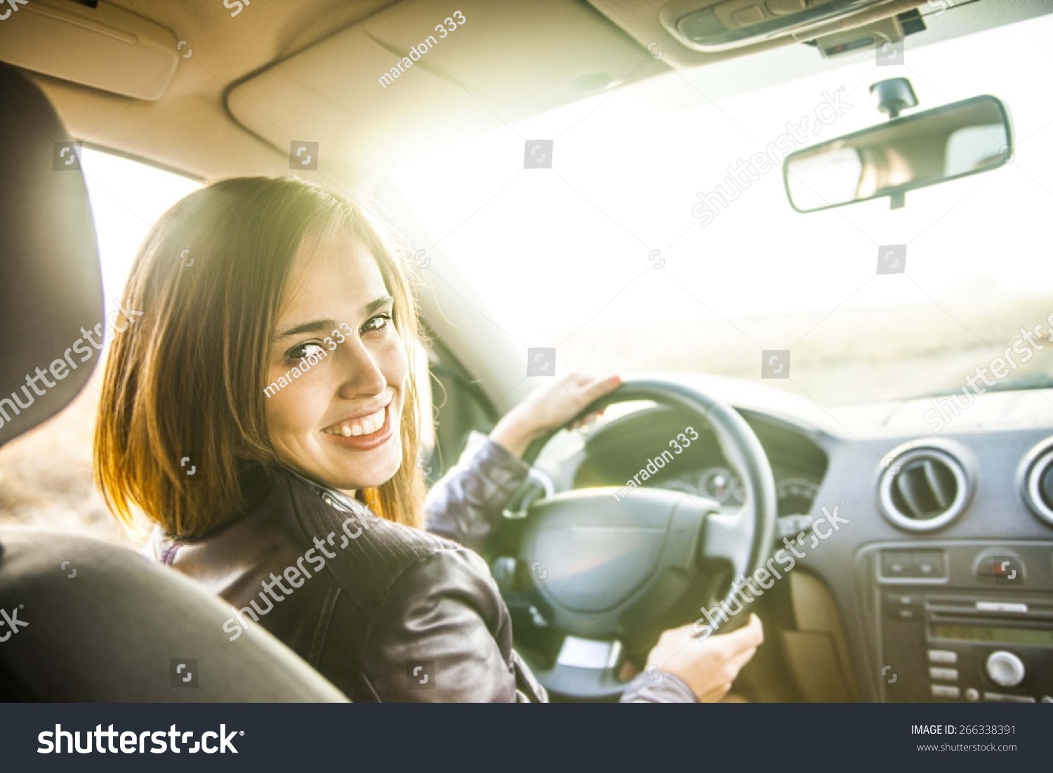 Woman In Car Indoor Keeps Wheel Turning Around Smiling Looking At Passengers In Back Seat Idea 