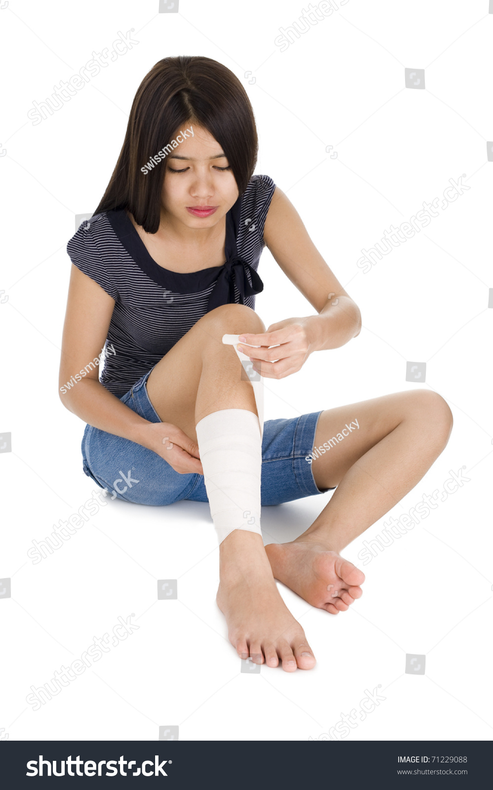 Woman Wrapping A Bandage Around Her Leg Isolated On White Background