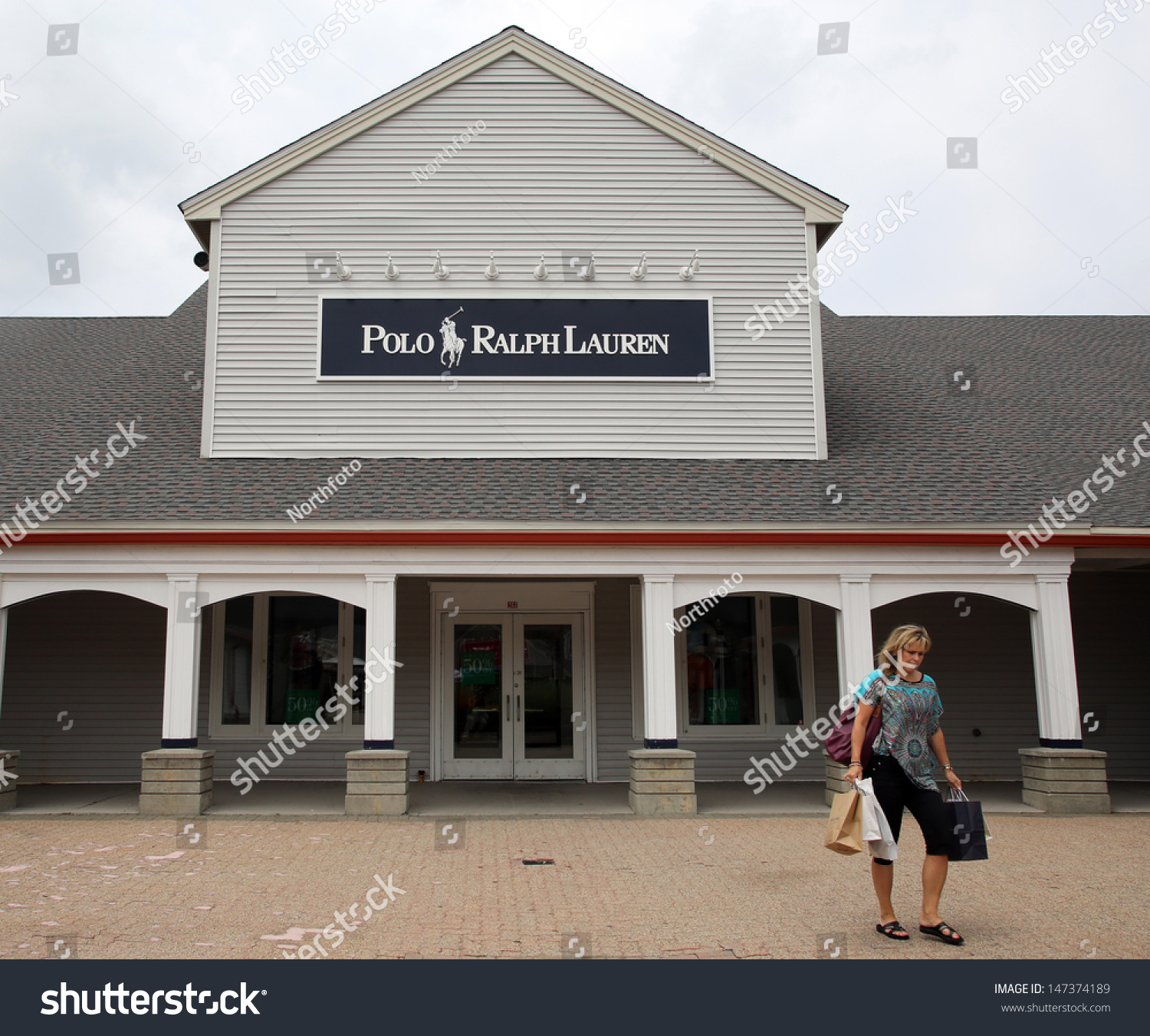 Woodbury Common - July 9: Shoppers Walk Past A Ralph Lauren Polo Retail Clothing Outlet Store In ...