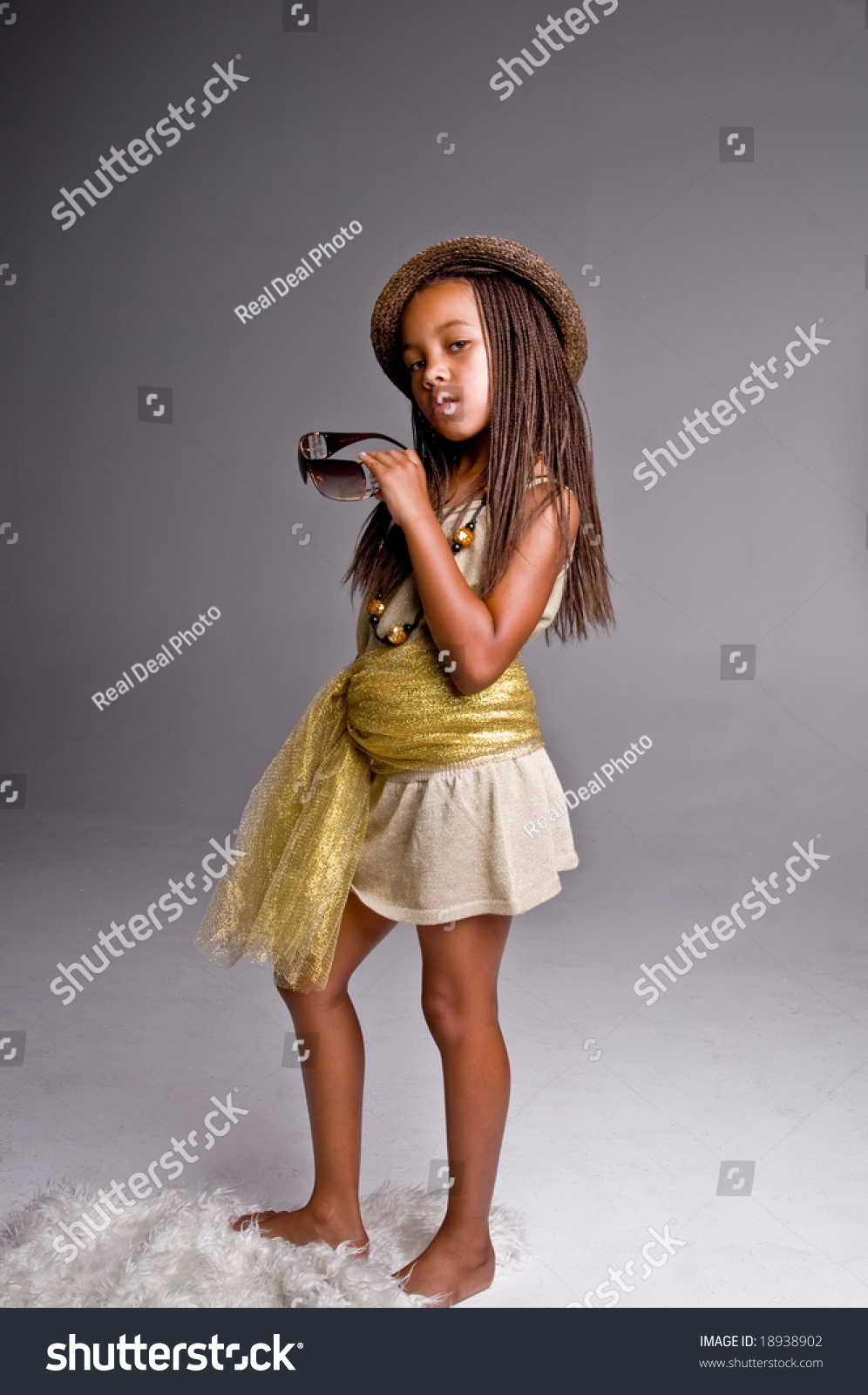 Young African American Girl Playing Dress Up In Mommies Shoes And Daddy