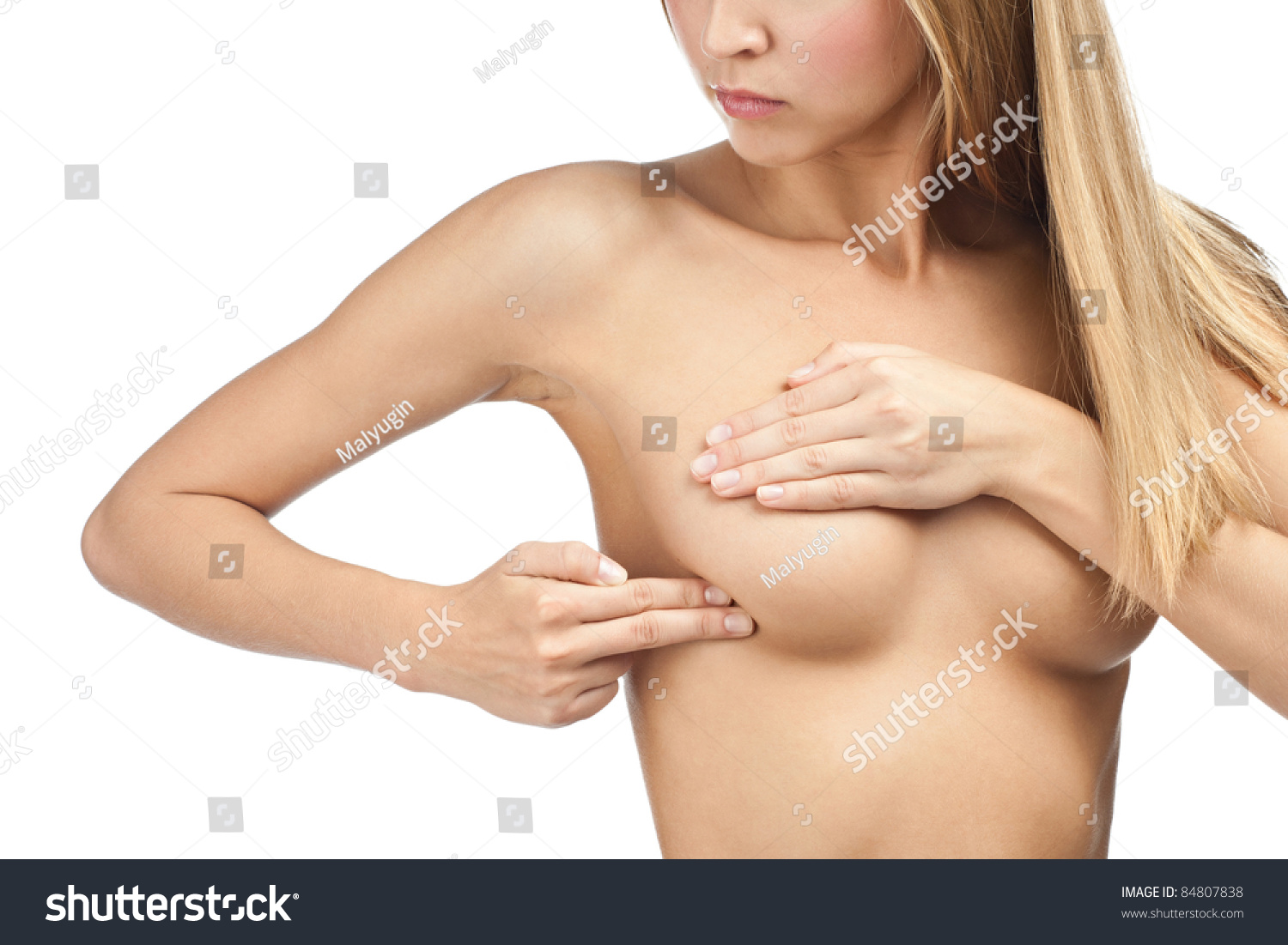 Young beautiful woman examining her breast for lumps or signs of breast cancer Young beautiful woman examining her breast for lumps or signs of breast cancer