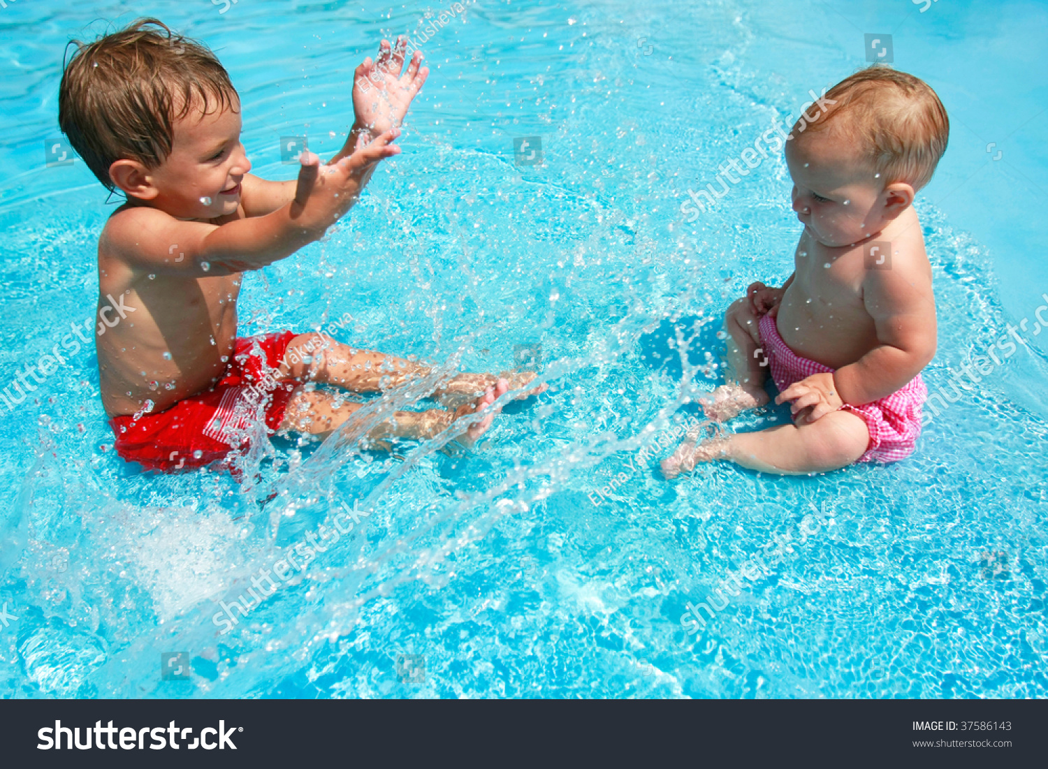 Brother And Sister Playing In Swimming Pool High-Res Stock 