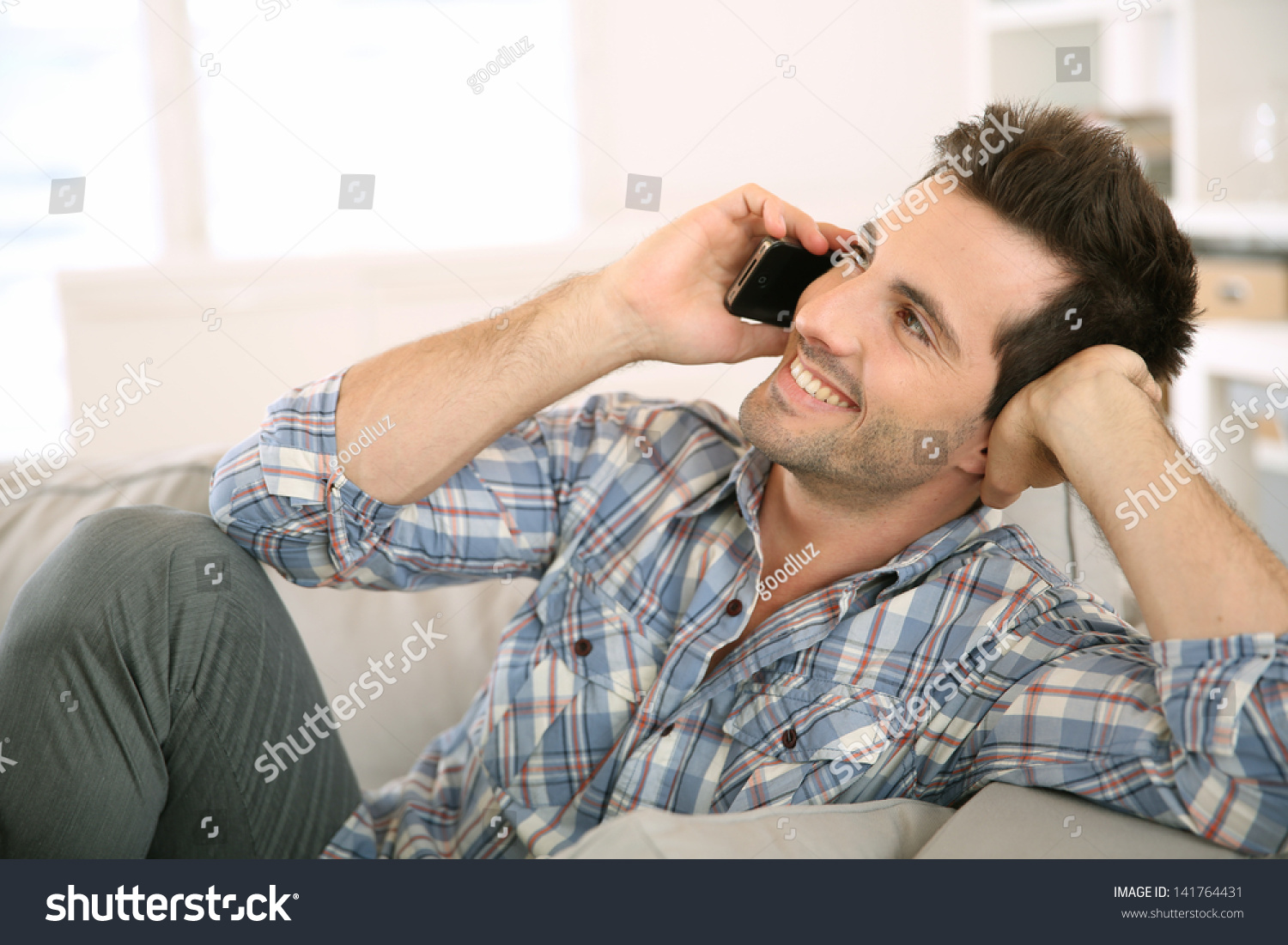 http://image.shutterstock.com/z/stock-photo-young-man-at-home-talking-on-mobile-phone-141764431.jpg