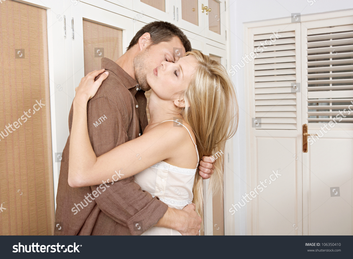 Young Passionate Couple Kissing In HomeS Bedroom Stock Photo