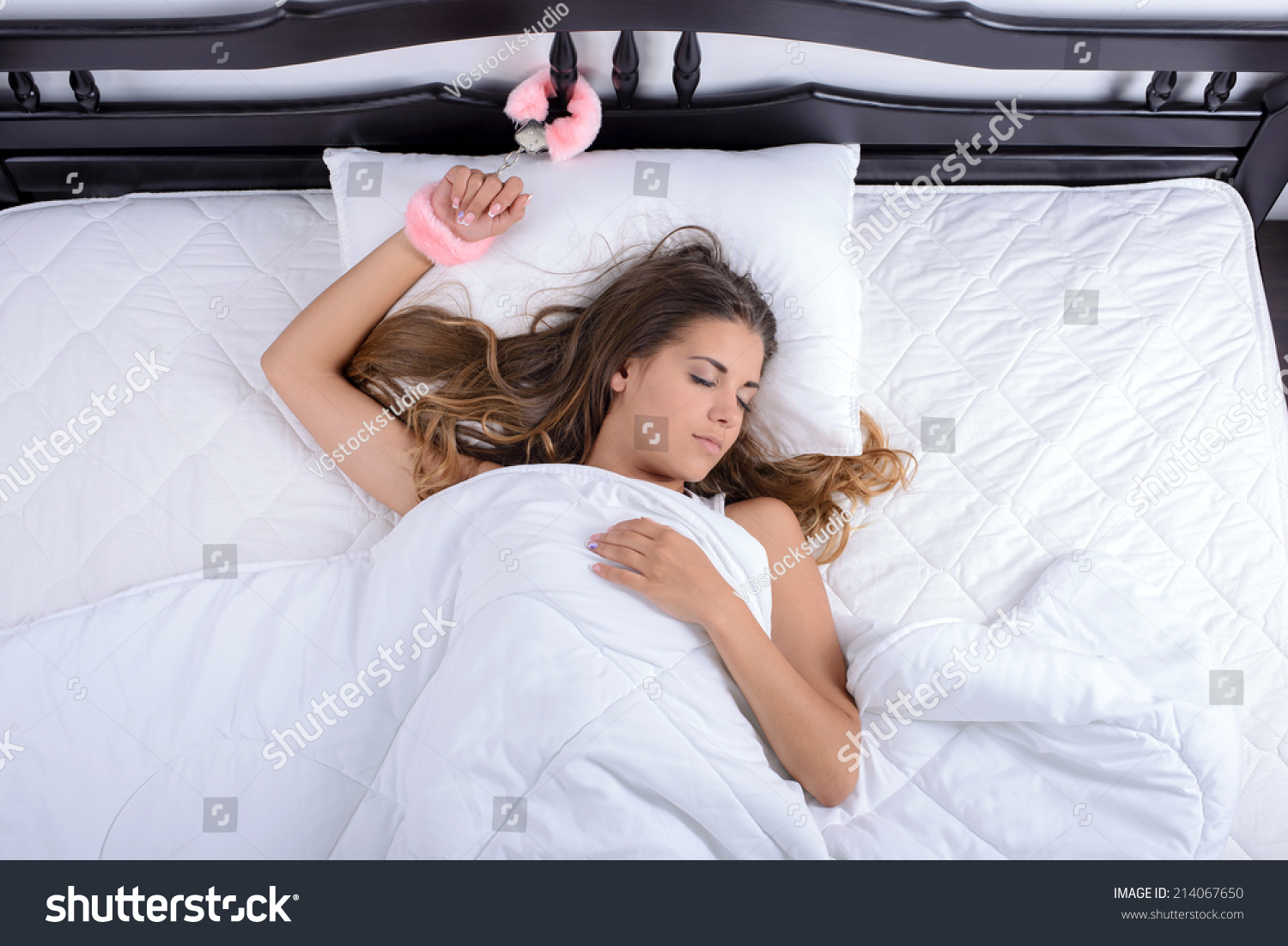 Young Sexy Girl Lying In Bed With Handcuffs Chained To A Bed In Her