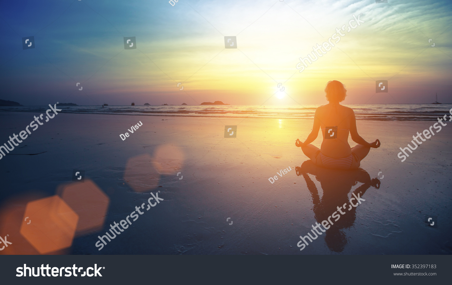Young woman silhouette practicing yoga on the beach at amazing sunset Young woman silhouette practicing yoga on the beach at amazing sunset