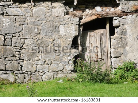 Rotten door in a stone wall of an old irish cottage