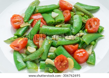 Close up, Stir fry sugar snap peas with tomato.