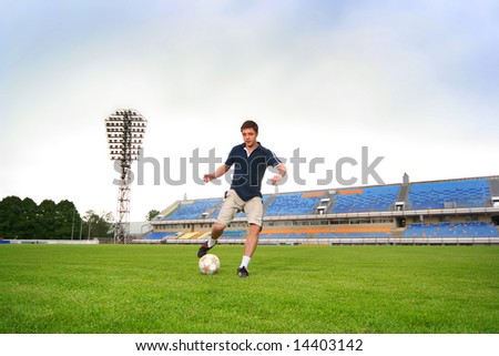 young guy playing football on stadium