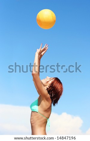 young girl playing volley-ball on the beach