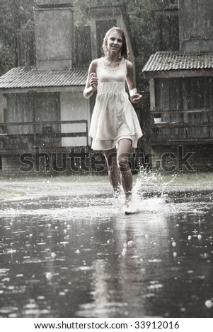 attractive young girl running in the rain