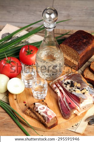Vodka and smoked meat on wooden table