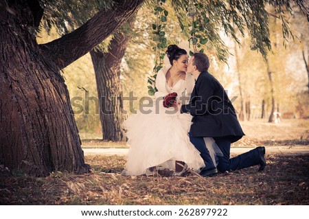 young funny bride and groom having fun in the park