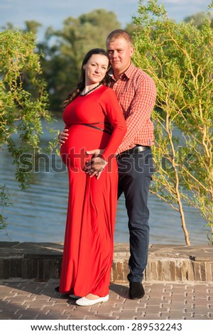 Happy family. A pregnant woman with her husband at the park.