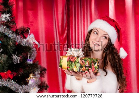 girl with gifts near a Christmas tree, long-awaited holiday, festive Christmas tree, happy face, festive attire.