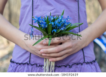 girl holding hands bouquet of blue snowdrops, hand holding blue snowdrops bouquet